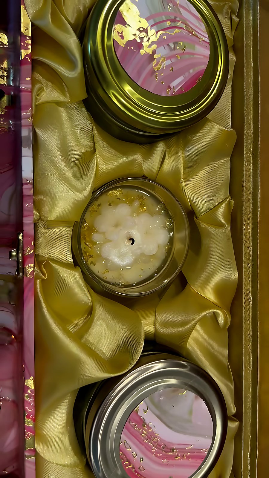 Jars nestled in gold satin inside a marble-finish hamper